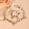 Golden titanium steel jewelry set featuring natural shell pendants with starfish and dolphins - Dolphin Set