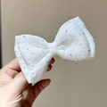Close-up of white mesh bow hair clip with sparkling silver polka dots for kids - White