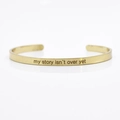 Minimalist 4mm gold stainless steel cuff bracelet with my story isn't over yet engraving - my story isn't over yet