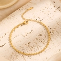 Elegante pulsera de bolas bañada en oro de 18K con cierre sobre fondo de piedra natural - Dorado