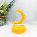 Detail shot of a yellow crescent moon night light with a cloud and heart switch base - Yellow