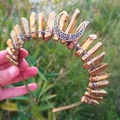 Close-up of golden crystal wizard crown featuring a hollow moon ornament on grass - Gold Crystal + White K Moon