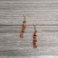 Handmade beaded earrings featuring natural red stone chips and golden hook accents - Gold-Red Agate