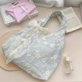 Detail of light blue floral embroidered canvas bag with a large white lace bow accent - Blue + Apricot Flower