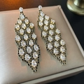 Detalle de pendientes dorados de lujo con borlas, piedras de pera y circonitas negras - Pin de Plata - Pendientes Colgantes de Borla de Circonita Dorada
