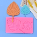 Pink silicone mold for palm leaf fondant with detailed orange and blue leaf replicas - Pleated Leaf (Style 1)