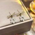 Golden bow and flower earrings with white rhinestones on a grey jewelry display - 30# Hollow Flower Studs