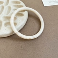 Macro detail of minimalist cream resin bangle with brown marble texture on ceramic tray - Thin Round / White