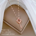 Macro d'un collier clé en or rose serti de diamants sur fond de boîte à bijoux - Clé Couronne (Or Rose) / Or rose