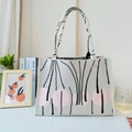 Close-up of knit texture on shoulder bag with abstract pink dots and black lines - Apricot