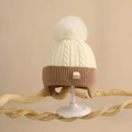 Dettaglio cappello in maglia neonato con trecce, design bicolore e grande pompon morbido - Taglia Unica (6 mesi-2 anni) / Bianco Sporco/Caffè Chiaro