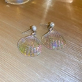 Macro shot of iridescent shell pearl earrings with a radiant rainbow shimmer on wood - Silver Needle - Iridescent Shell Drop Earrings