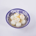 Bolas de arroz pegajoso blanco con coberturas en un tazón de cerámica azul y blanco - Tangyuan de Osmanto