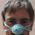 Close-up of light blue hand-knitted crochet nose warmer accessory worn by a male model - 5CM Diameter / Sky Blue