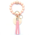 Detail of pink silicone beads, geometric wood bead and tassel on a wristlet keychain - Orange