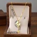 Gold titanium steel tassel necklace featuring letter M pendant in dark wooden jewelry box - M / Gold