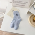 Light blue speckled cotton crew socks with black heart embroidery in a lifestyle setting - One Size / Fog Blue