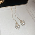 Detail of elegant gold tassel earrings featuring delicate pearls and baroque pendants - 7 Ear Hook Gold