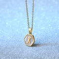 Hexagon gold necklace with letter X and white shell inlay on a shimmering background - Letter X