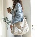 Japanese style canvas messenger bag in cream white with multi-pocket design on model - Off White
