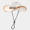 Détail d'un chapeau de cow-boy en paille blanche avec bandeau léopard et jugulaire réglable - Taille unique / Blanc