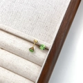 Green crystal stud earrings with gold titanium steel screw back on beige linen display - Green Round (6mm)
