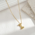 Minimalist gold necklace with a chunky 3D letter I pendant on a white marble stand - Letter I
