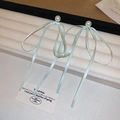 Detail view of light green satin ribbon bow earrings with elegant white pearls on a display - 28# Silver Earring Post - Green Ribbon Bow Pearl