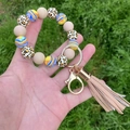 Close-up of beaded silicone keychain bracelet with leopard print and leather tassel - Nude Leopard Marble Style