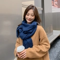 Close-up of a navy blue fringed scarf worn by a model in a natural outdoor setting - Navy Blue