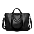 Dettaglio della texture di una borsa tote in pelle nera con tracolla robusta - Nero