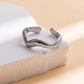 Detailed view of silver wavy open ring made of stainless steel on white stone base - Steel Color 39
