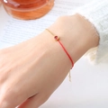 Red cord and gold plated chain bracelet with a round red gemstone pendant detail - June Orange Red