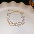 Three-layer gold chain bracelet with white pearls elegantly displayed on a ceramic dish - 74# Bracelet-Gold-6mm