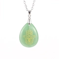 Makro-Detail des grünen Kristallanhängers mit goldener Hamsa-Hand an einer Silberkette - Aventurin/Edelstahlkette
