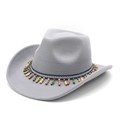Détail d'un chapeau de cowboy en feutre gris avec ruban ethnique et glands en perles - Gris clair