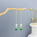 Detail of long gold earrings with gradient green beads hanging from a rustic wooden branch - Gold Chain Gradient Bead Tassel Earrings(E3432)