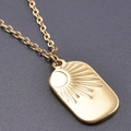 Macro view of gold sun and moon rectangular pendant with minimalist engraved details - Gold Necklace