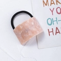 Close-up of pink marble acetate geometric hair tie on a white textured background - Pink