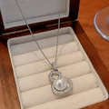 Detailed shot of hollow gourd necklace with large pearl and sparkling crystals in a box - Style 16