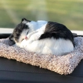 Close-up of a lifelike black and white plush cat sleeping on a soft fuzzy cushion - Large Black and White Spotted Cat
