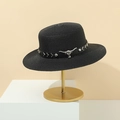 Black straw boater hat with leather band and metal bull head ornament on a gold stand - Black