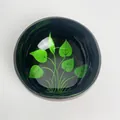 Close-up of coconut shell bowl with black exterior and green leaf inlay pattern - Green Leaf Style