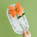 Handmade crochet orange lily flower with green leaves and a white ribbon bow decor - Lily - Orange