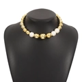 Detail of chunky gold beads and white pearls on a stylish short choker necklace - Gold