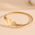 Détail d'un bracelet à breloque cœur doré avec un design de bracelet en câble torsadé - Style Pendentif Cœur Doré (G716)