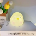 Cute yellow chick night light glowing with warm light on a white table setting - Cute Chick