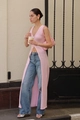 Detail view of light pink long knit vest featuring a deep V-neck and high front slit design - S / Pink