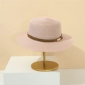 Close-up of pink straw sun hat with brown leather band and gold buckle on a stand - M (56-58cm) / Lotus Pink