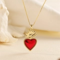 Elegante gouden ketting met een rode hart- en vlamhanger op zachte stof - Heilig Hart Vlam